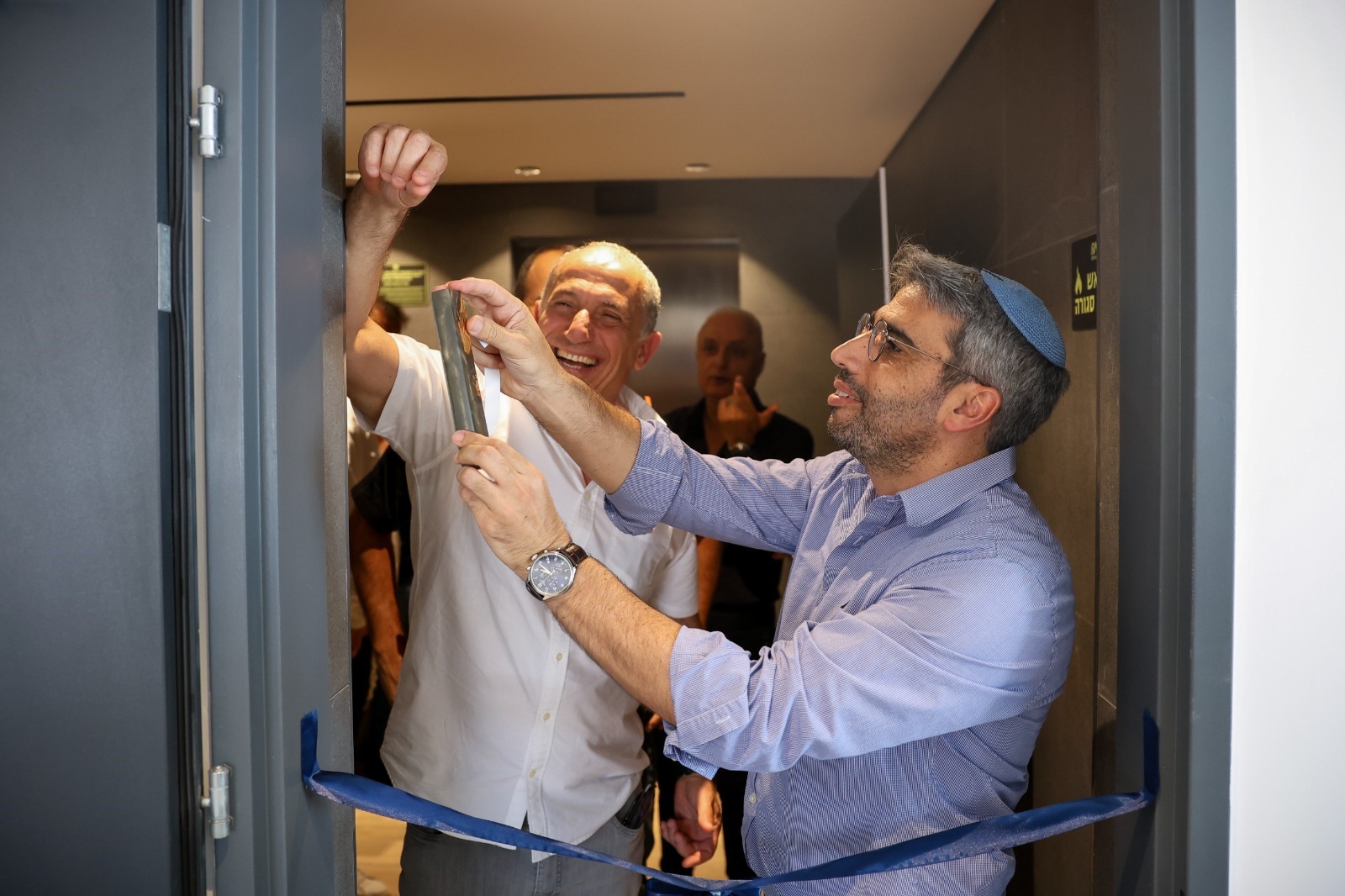 ראש העיר אריאל, יאיר שיטבון, ודורון נמרוד, מנכ''ל רם אדרת בטקס התקנת המזוזה בדירה לדוגמא. צילום: יוסי קרסו